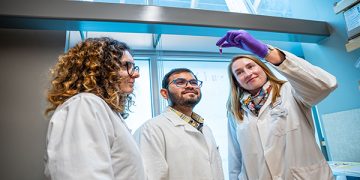 Dr. Anna Blakney in a life sciences research lab with colleagues