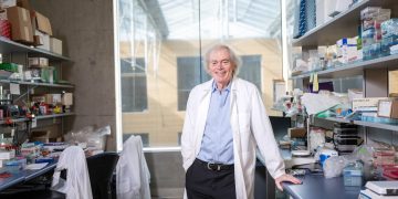 Dr. Pieter Cullis portrait in a white lab coat pictured in lab