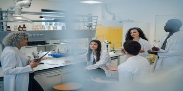 photo of a lab with 5 researchers in lab coats